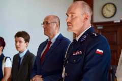 Funkcjonariusz w galowym mundurze oraz Mariusz Przytuła biorący udział w ceremonii wręczenia odznaczenia Medal za długoletnią służbę.