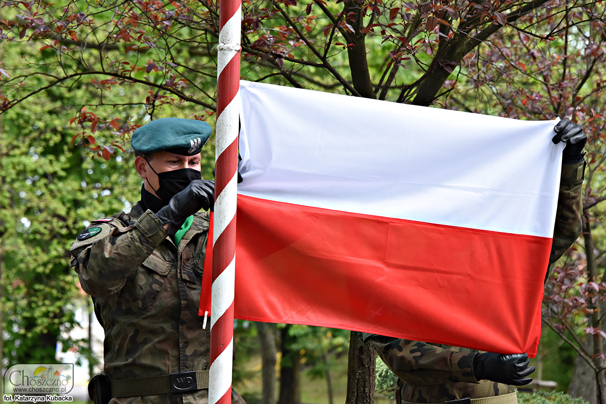 żołnierze podnoszą flagę Polski na maszt